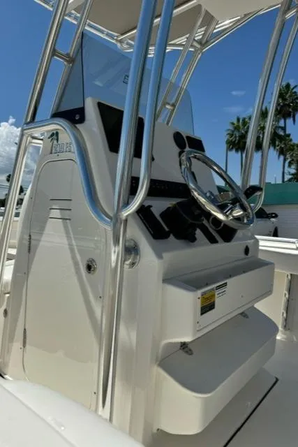 Slide: The Image of 2026 Key West 219 FS boat console with steering wheel and controls, under clear blue sky. - 11