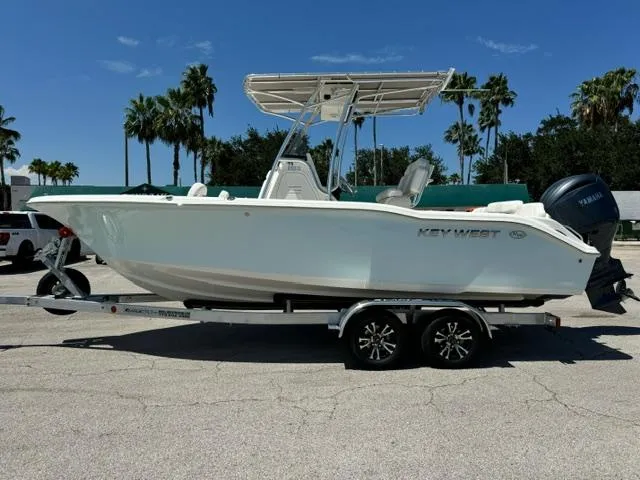 Slide: The Image of 2026 Key West 219 FS boat on trailer, parked outdoors under clear blue sky. - 2
