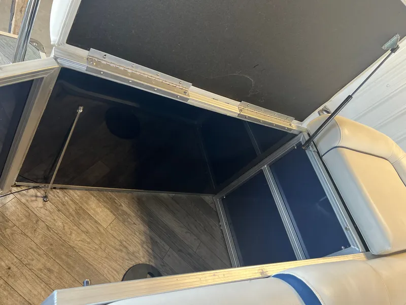 Slide: The Image of Open storage compartment in 2018 Berkshire 23 CLSTS2.75 boat, featuring blue interior and cushioned seating. - 15