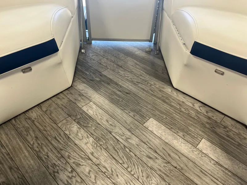 Slide: The Image of Interior of 2018 Berkshire 23 CLSTS2.75 boat with wood-style flooring and white seating. - 16