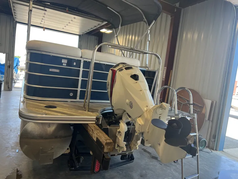 Slide: The Image of 2018 Berkshire 23 CLSTS2.75 pontoon boat with outboard motor in a garage. - 2