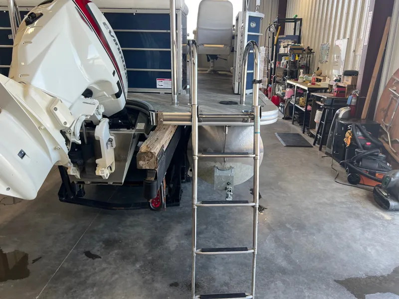 Slide: The Image of 2018 Berkshire 23 CLSTS2.75 pontoon boat with Evinrude outboard motor in a workshop. - 21