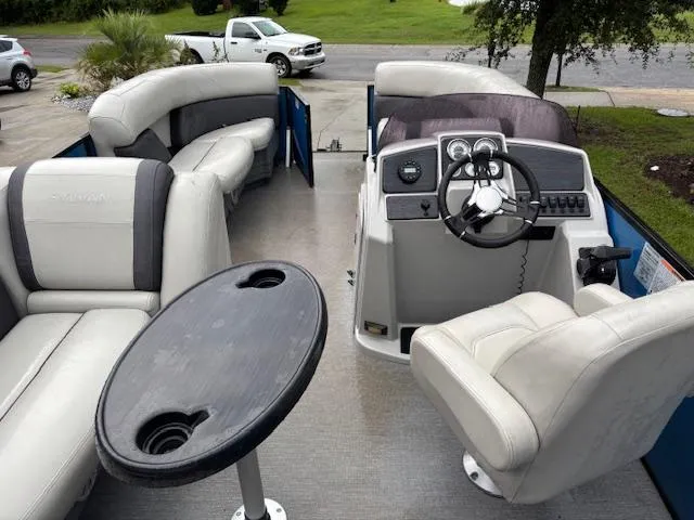 Slide: The Image of 2021 Sylvan Mirage 820 Cruise interior with plush seating and steering console. - 10
