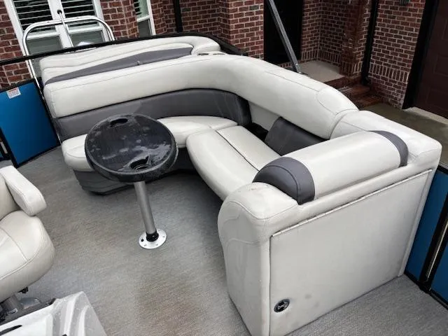 Slide: The Image of 2021 Sylvan Mirage 820 Cruise boat interior with gray seating and a small round table. - 13