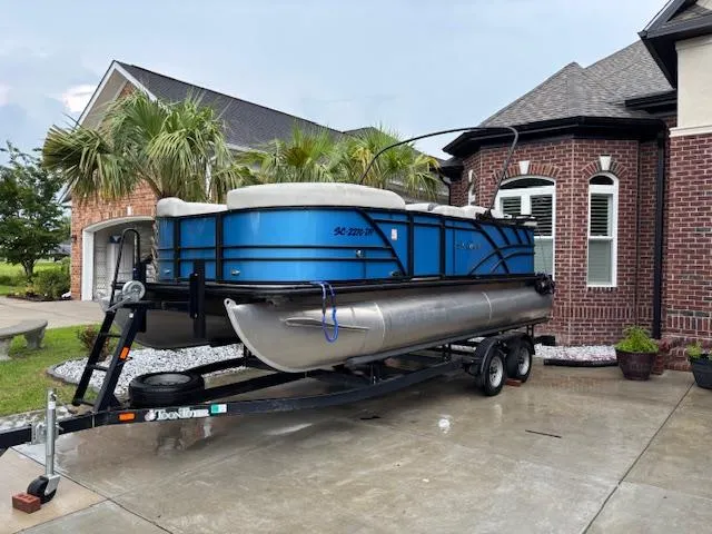 Slide: The Image of 2021 Sylvan Mirage 820 Cruise pontoon boat on trailer, parked in driveway near brick house. - 8