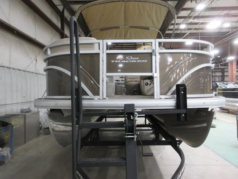 Slide: The Image of 2024 Sun Tracker SportFish 20 DLX pontoon boat in indoor storage facility. - 2