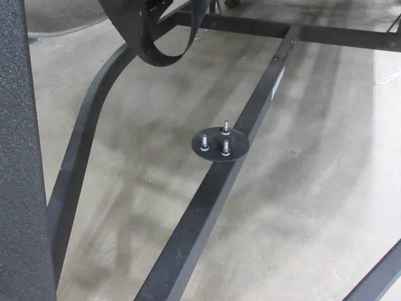 Slide: The Image of 2024 Sun Tracker SportFish 20 DLX trailer frame detail with bolts on concrete floor. - 6