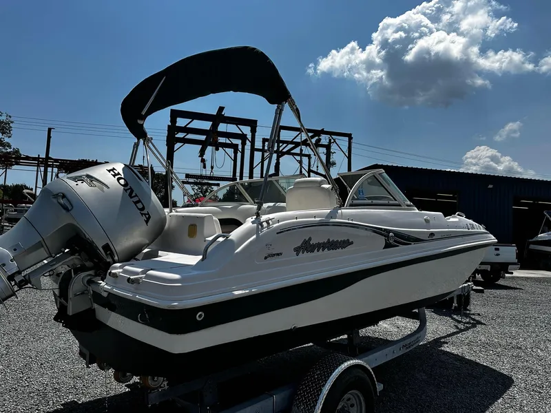 Slide: The Image of 2002 Godfrey Hurricane SD187 boat with Honda outboard motor on a trailer, under a blue sky. - 2