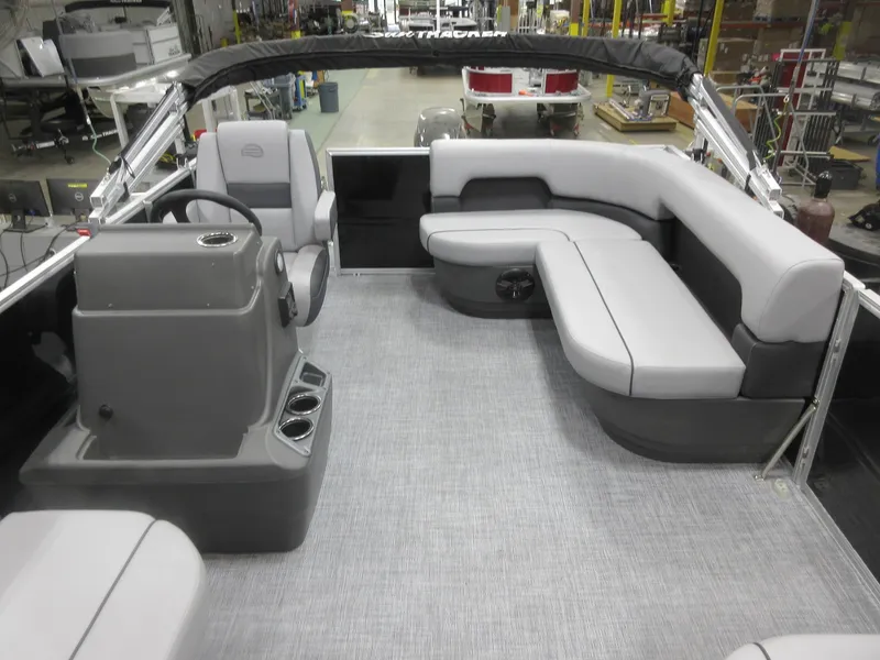 Slide: The Image of 2026 Sun Tracker Party Barge 16 DLX interior with gray seating and helm. - 4