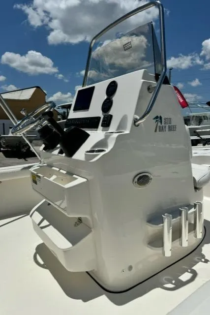 Slide: The Image of 2026 Key West 210 Bay Reef boat console with steering wheel and controls under a blue sky. - 10