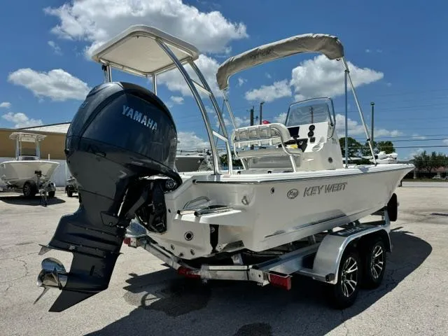 Slide: The Image of 2026 Key West 210 Bay Reef boat with Yamaha engine on a trailer, parked outdoors. - 4