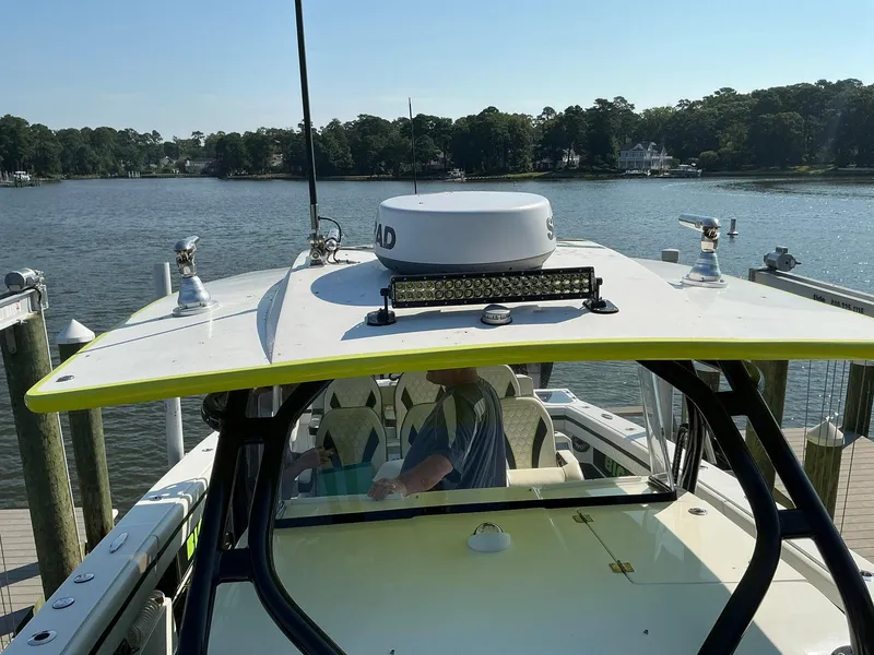 Slide: The Image of 2020 Prowler 42 boat docked by a scenic waterfront with lush greenery. - 11