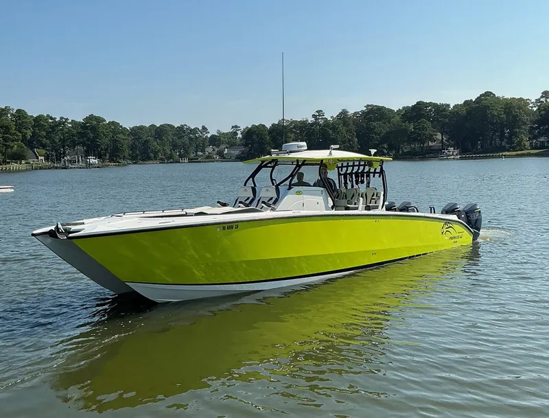 Slide: The Image of 2020 Prowler 42 boat in vibrant yellow on a calm lake. - 4
