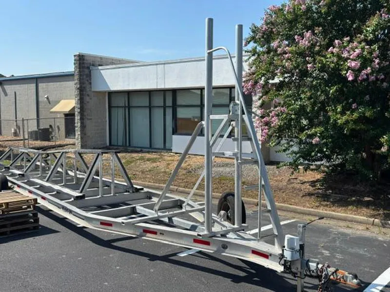Slide: The Image of Trailer frame parked outdoors near a building, surrounded by greenery. - 40