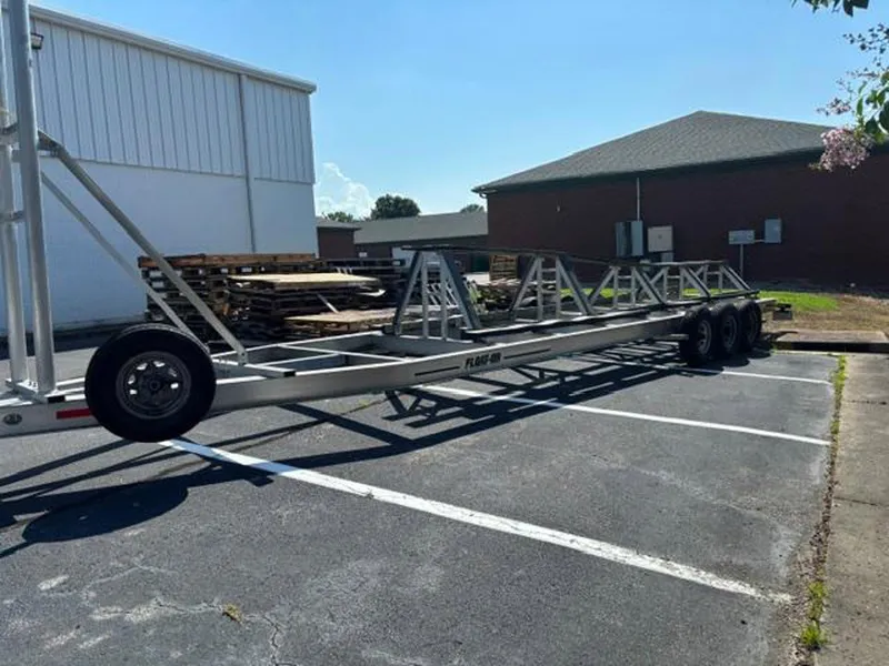 Slide: The Image of Trailer parked in a lot, Prowler 42 model, 2020, with metal frame and multiple axles. - 41