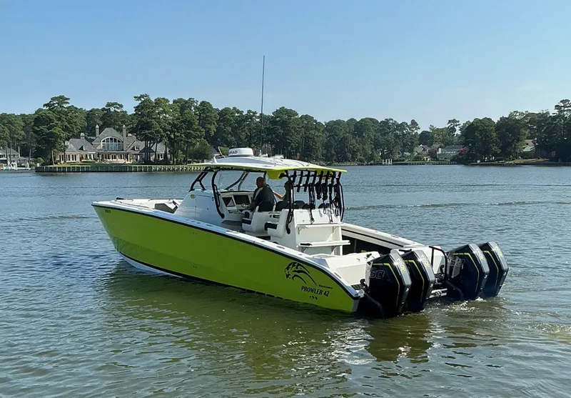 Slide: The Image of 2020 Prowler 42 boat with multiple engines cruising on a serene lake. - 5