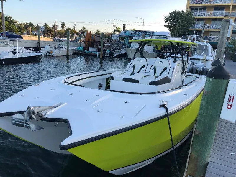 Slide: The Image of 2020 Prowler 42 boat docked, featuring a sleek white and lime green design. - 7