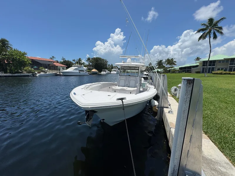 Slide: The Image of 2023 Sea Fox 368 Commander boat on water, American flag, cloudy sky background. - 1
