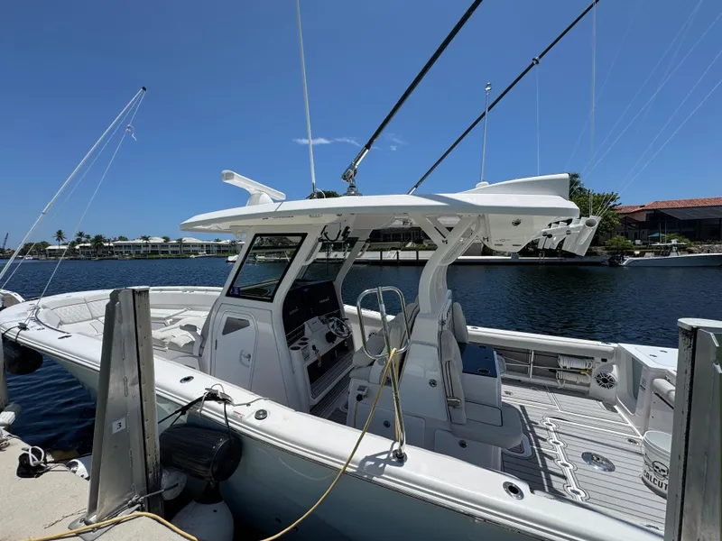 Slide: The Image of 2023 Sea Fox 368 Commander boat docked by waterfront homes under a clear blue sky. - 4