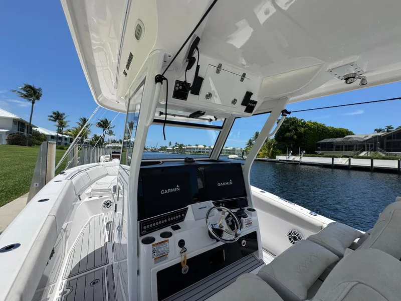 Slide: The Image of 2023 Sea Fox 368 Commander boat interior with seating and canopy on a calm lake. - 6
