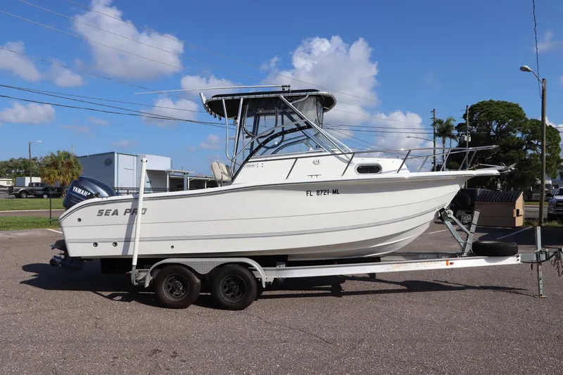 The Image of 2004 Sea Pro 220 Walk Around boat on trailer, clear sky background. - 0