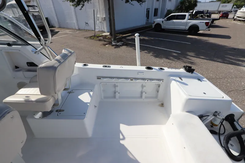 Slide: The Image of 2004 Sea Pro 220 Walk Around boat interior with seating and storage compartments. - 12