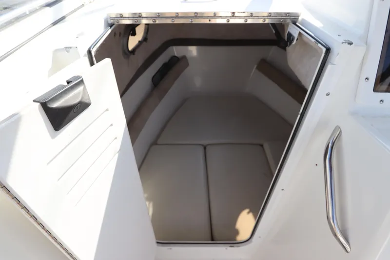 Slide: The Image of 2004 Sea Pro 220 Walk Around cabin interior with cushioned seating. - 17