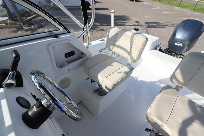 Slide: The Image of 2004 Sea Pro 220 Walk Around boat interior with steering wheel and seating. - 19