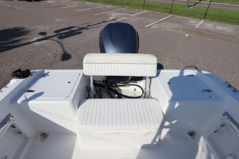 Slide: The Image of 2004 Sea Pro 220 Walk Around boat interior with seating and engine view. - 8