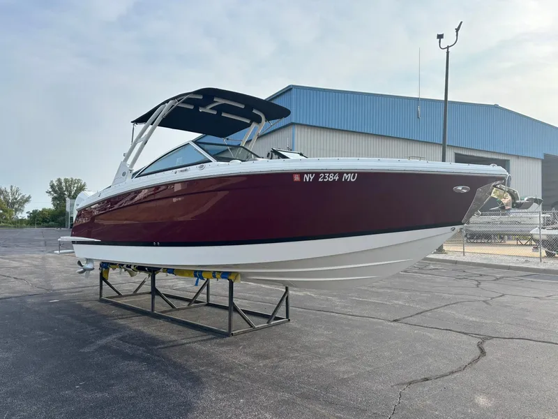 Slide: The Image of 2024 Cobalt R8 Outboard boat on display, maroon and white, in a marina setting. - 12