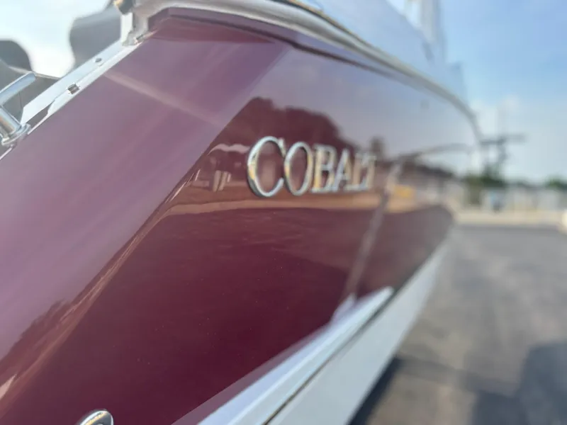 Slide: The Image of 2024 Cobalt R8 Outboard boat with maroon and white exterior detailing. - 8