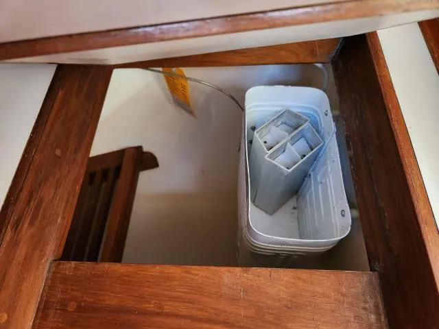 Slide: The Image of Wooden interior of 1983 Hans Christian HC33 with storage compartment and plastic container. - 11