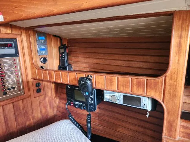Slide: The Image of 1983 Hans Christian HC33 yacht interior with communication equipment and wooden paneling. - 16