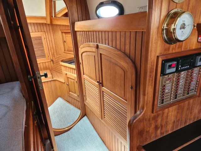 Slide: The Image of 1983 Hans Christian HC33 yacht interior with wooden cabinetry and nautical instruments. - 23