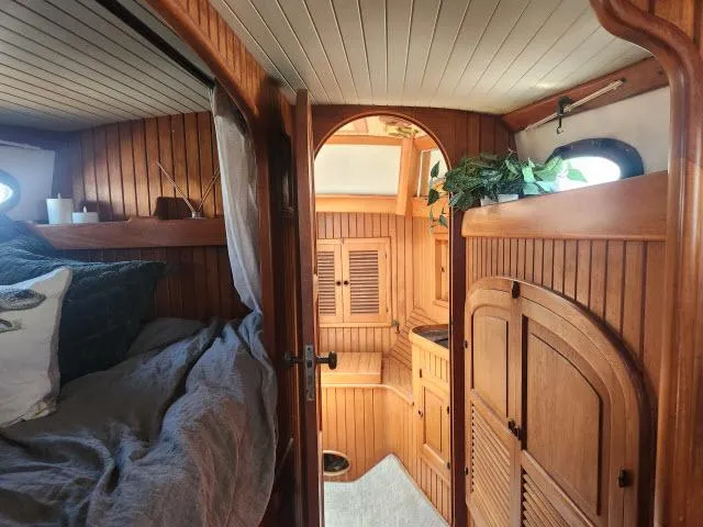 Slide: The Image of Cozy 1983 Hans Christian HC33 boat interior with wooden paneling and comfortable bedding. - 24
