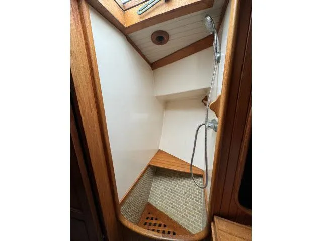 Slide: The Image of Shower area in 1983 Hans Christian HC33 sailboat with wooden accents and tiled floor. - 28