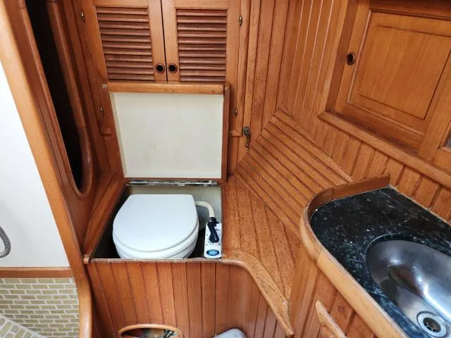 Slide: The Image of 1983 Hans Christian HC33 yacht bathroom with wooden cabinetry and compact toilet. - 29