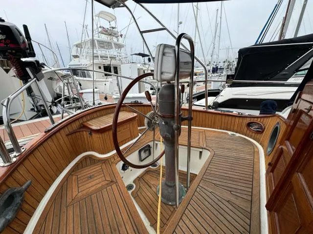 Slide: The Image of 1983 Hans Christian HC33 sailboat cockpit with wooden deck and steering wheel in marina. - 37