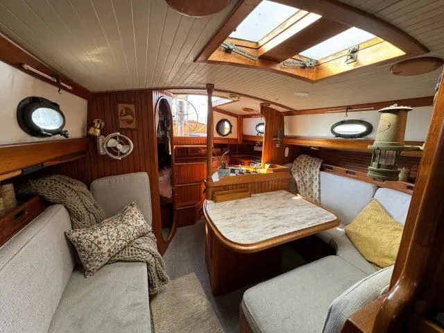 Slide: The Image of Cozy interior of 1983 Hans Christian HC33 sailboat with wooden finishes and seating area. - 4