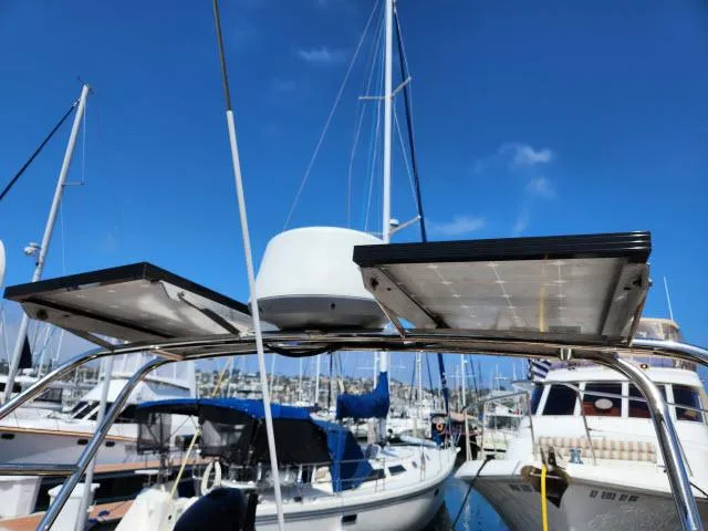 Slide: The Image of 1983 Hans Christian HC33 sailboat with solar panels in a marina under clear blue sky. - 41