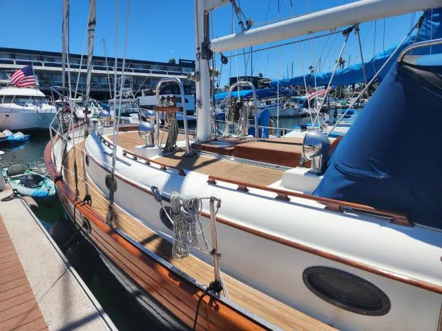 Slide: The Image of 1983 Hans Christian HC33 sailboat docked at a marina, showcasing its classic wooden deck. - 45