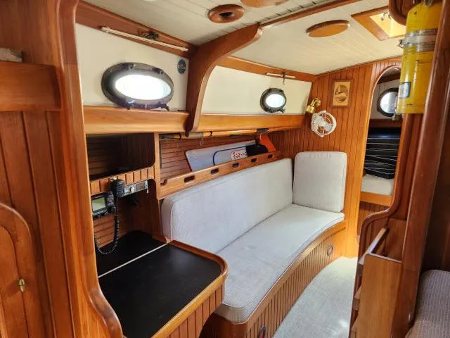 Slide: The Image of 1983 Hans Christian HC33 sailboat interior with wooden finish and cozy seating area. - 7