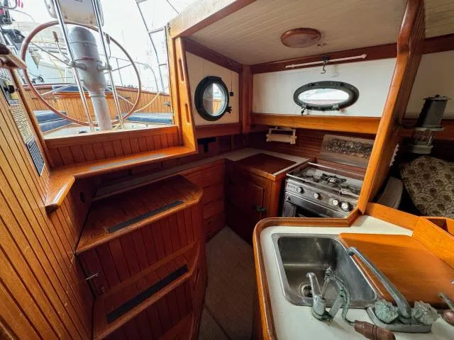 Slide: The Image of 1983 Hans Christian HC33 yacht interior with wooden cabinetry, stove, and sink. - 8
