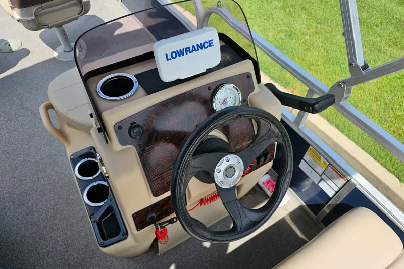Slide: The Image of 2019 Sun Tracker Bass Buggy 16 DLX steering console with Lowrance device and cup holders. - 2