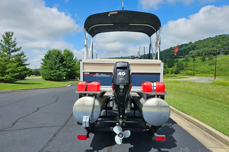 Slide: The Image of 2019 Sun Tracker Bass Buggy 16 DLX pontoon boat with Mercury 40 HP engine, parked outdoors. - 9