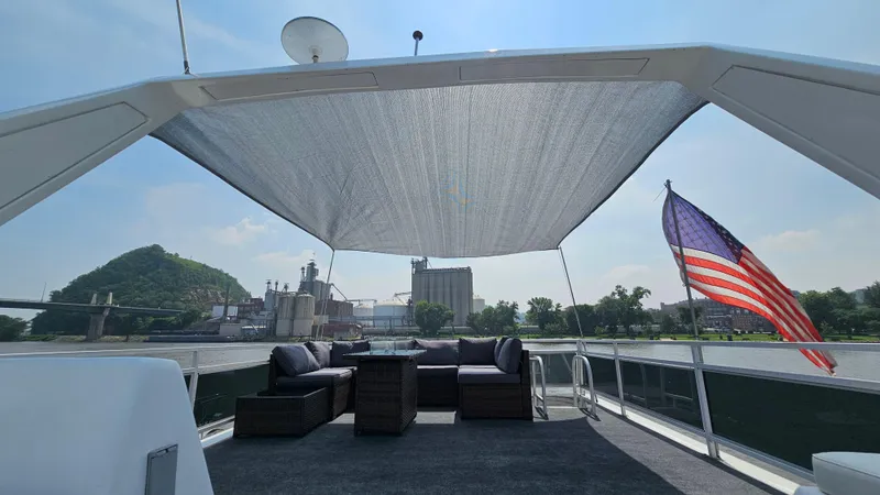 Slide: The Image of 1993 Skipperliner 47 SL yacht deck with seating, sunshade, and American flag on a river. - 15