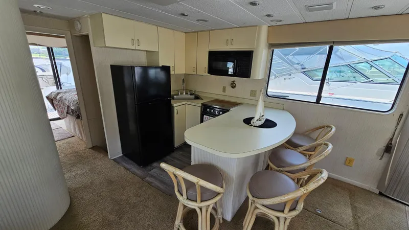 Slide: The Image of Interior of 1993 Skipperliner 47 SL with kitchen, bar seating, and window view. - 23