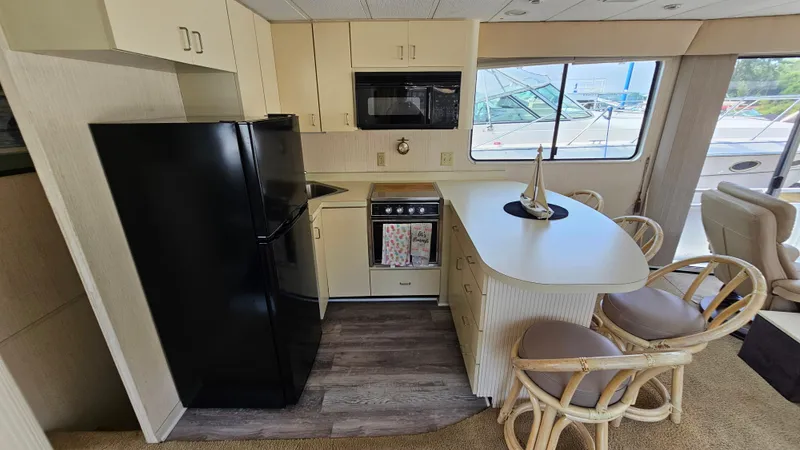 Slide: The Image of 1993 Skipperliner 47 SL kitchen with black fridge, microwave, and bar seating. - 24