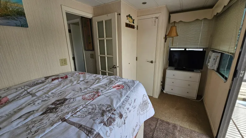 Slide: The Image of Cozy bedroom in 1993 Skipperliner 47 SL with TV, dresser, and decorative bedding. - 26