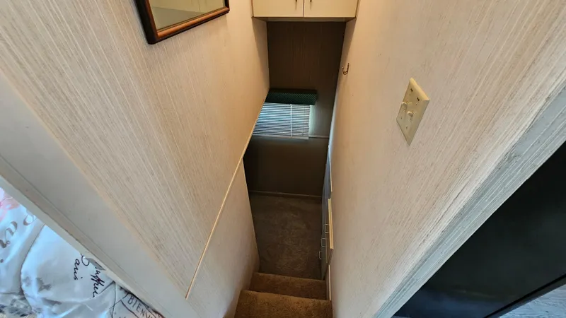 Slide: The Image of Narrow stairway inside 1993 Skipperliner 47 SL with carpet and small window. - 28